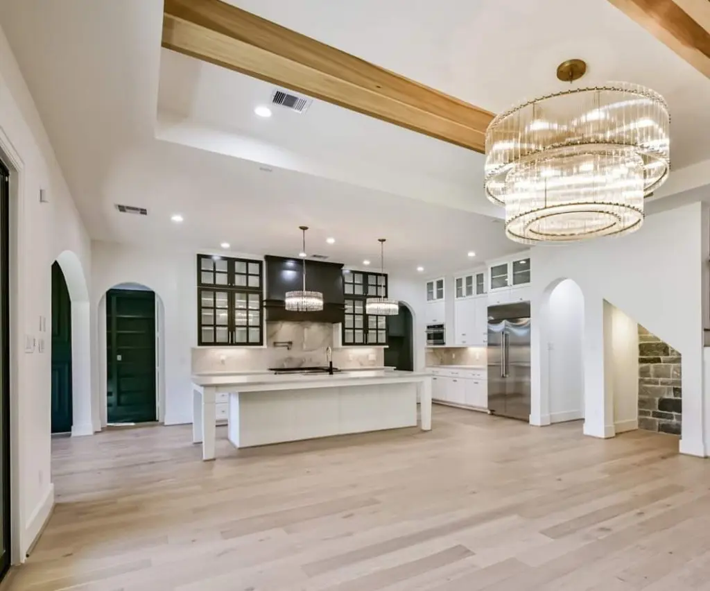 Elegant, open-concept kitchen featuring crisp white paint and dark cabinet accents by Texas Star Painting of Austin.