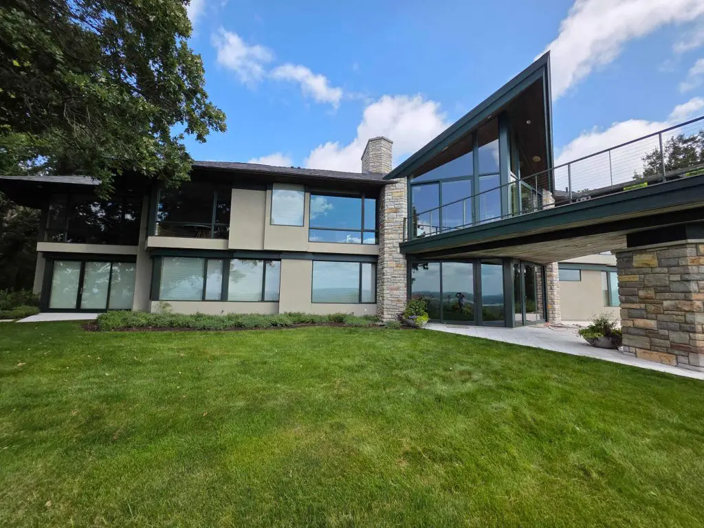 A stunning, modern architectural home featuring expansive glass, stone accents, and a freshly painted facade by Local Painters in Lakeway, TX