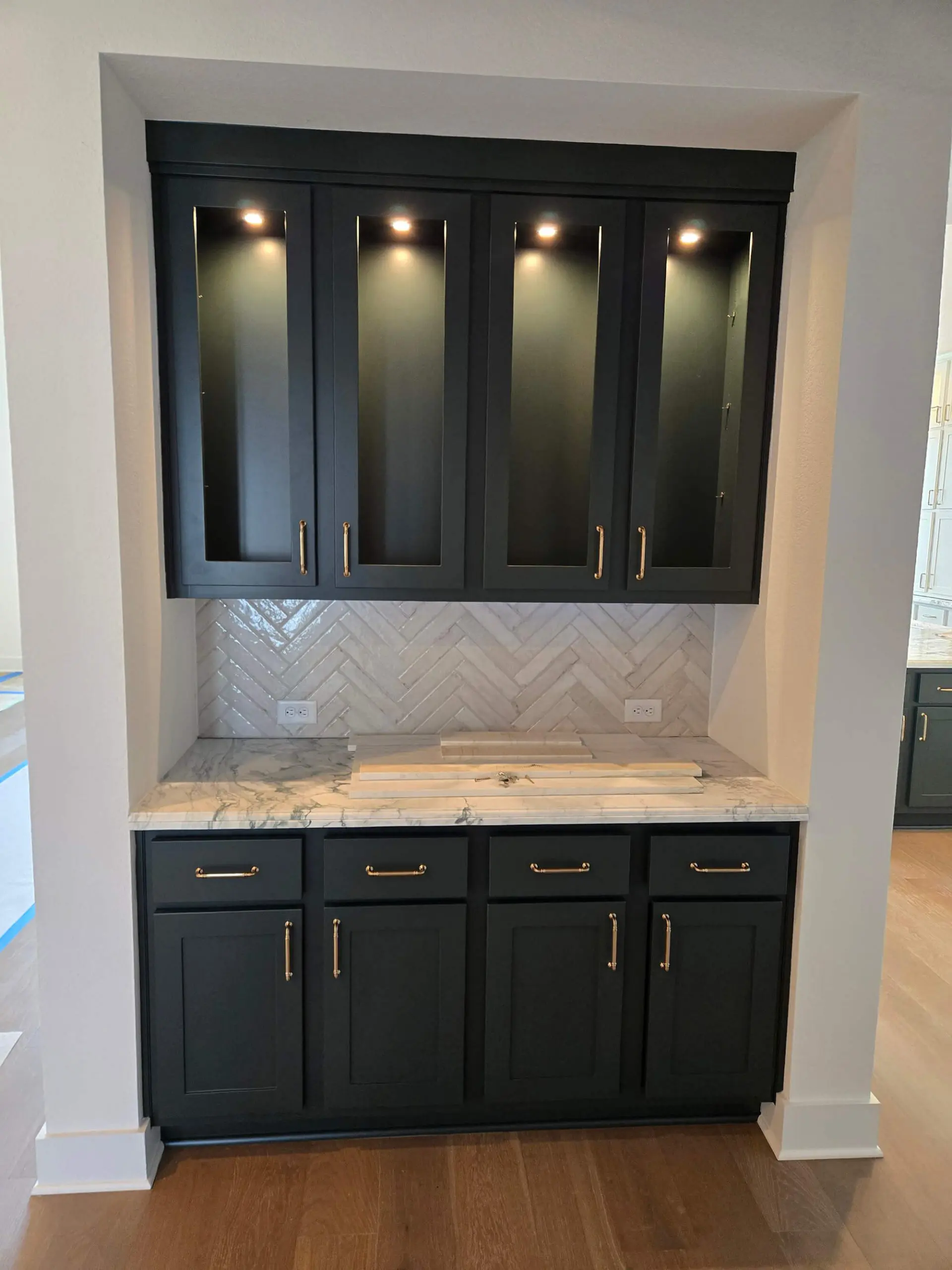 Open-concept kitchen with dark wood-stained cabinets and a large granite island, finished beautifully by Texas Star Painting of Austin.