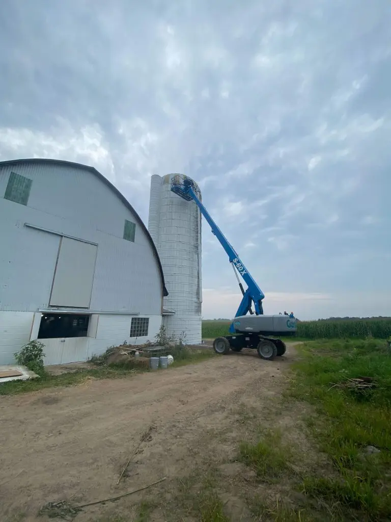 The elevated view captures a sleek, modern utility building featuring the warm contrast of horizontal brown siding above a natural stone foundation, a testament to the diverse projects handled by Texas Star Painting of Austin.