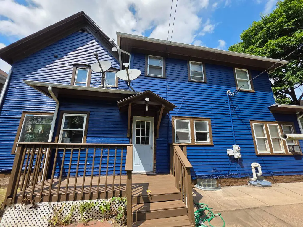 Vibrant blue siding with brown trim and a wooden deck on a multi-story home, showcasing exterior painting expertise from Texas Star Painting of Austin.