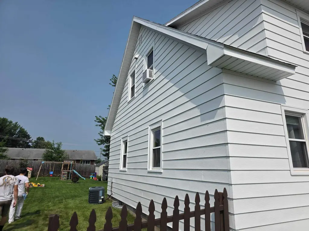 Freshly applied white exterior siding on a suburban home, expertly painted by Texas Star Painting of Austin.