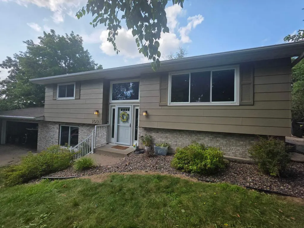 A beautiful pair of historic homes, one a classic two-story and the other a charming bungalow, both freshly finished in rich green and crisp white by Texas Star Painting of Austin.