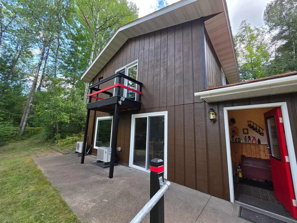 Rich, dark brown wood-sided cabin refresh with striking red accents by Texas Star Painting of Austin.