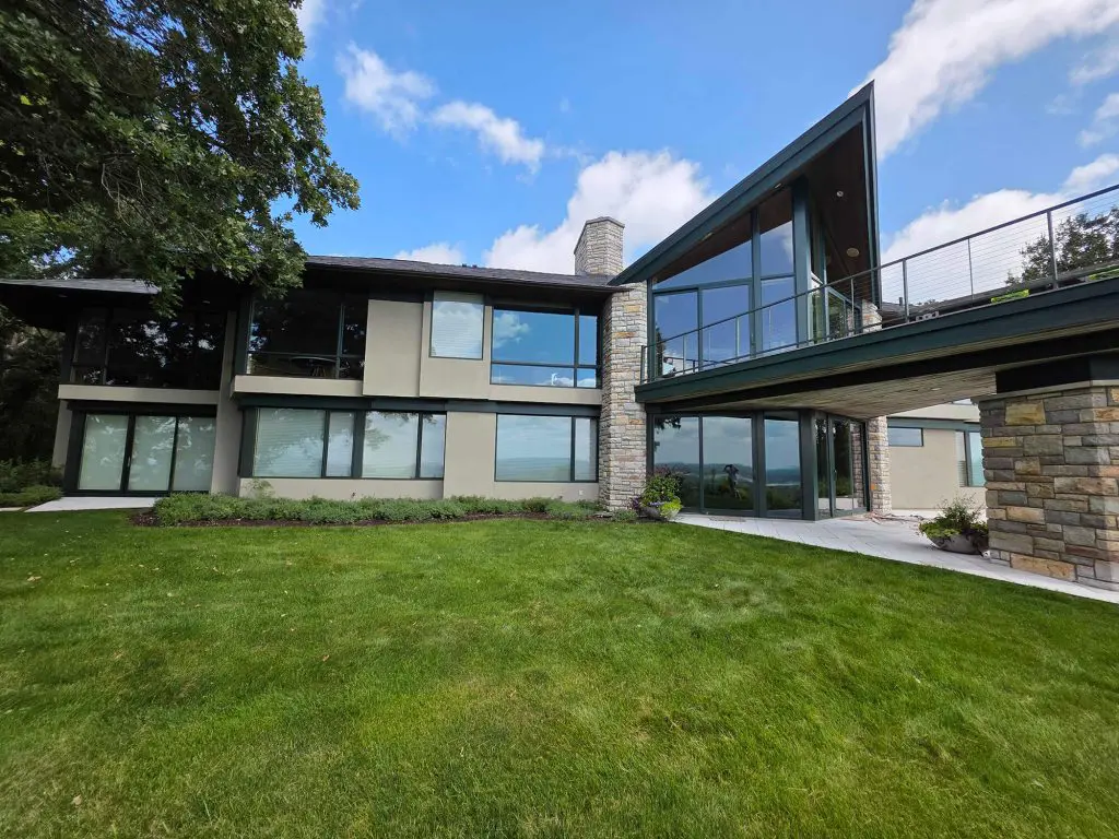 A stunning, modern architectural home featuring expansive glass, stone accents, and a freshly painted facade by Local Painters in Lakeway, TX