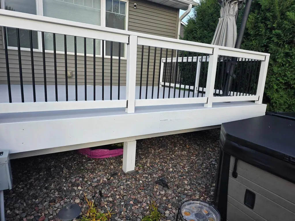A clean, modern deck with gray floor planks and crisp white railings, finished beautifully by Texas Star Painting of Austin.