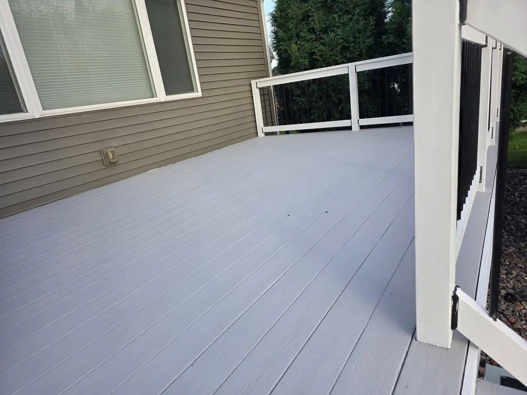 Freshly applied light gray deck coating with bright white railings, expertly finished by Texas Star Painting of Austin.