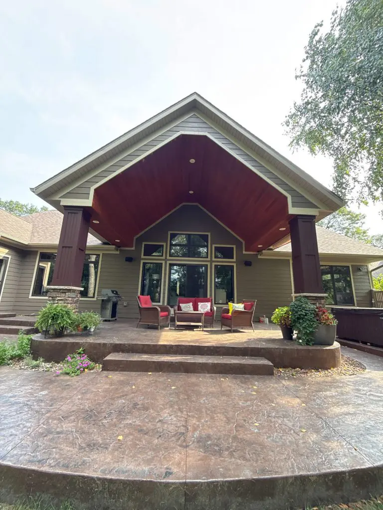 A luxurious outdoor living space featuring rich mahogany ceiling and substantial painted columns, by Texas Star Painting of Austin.
