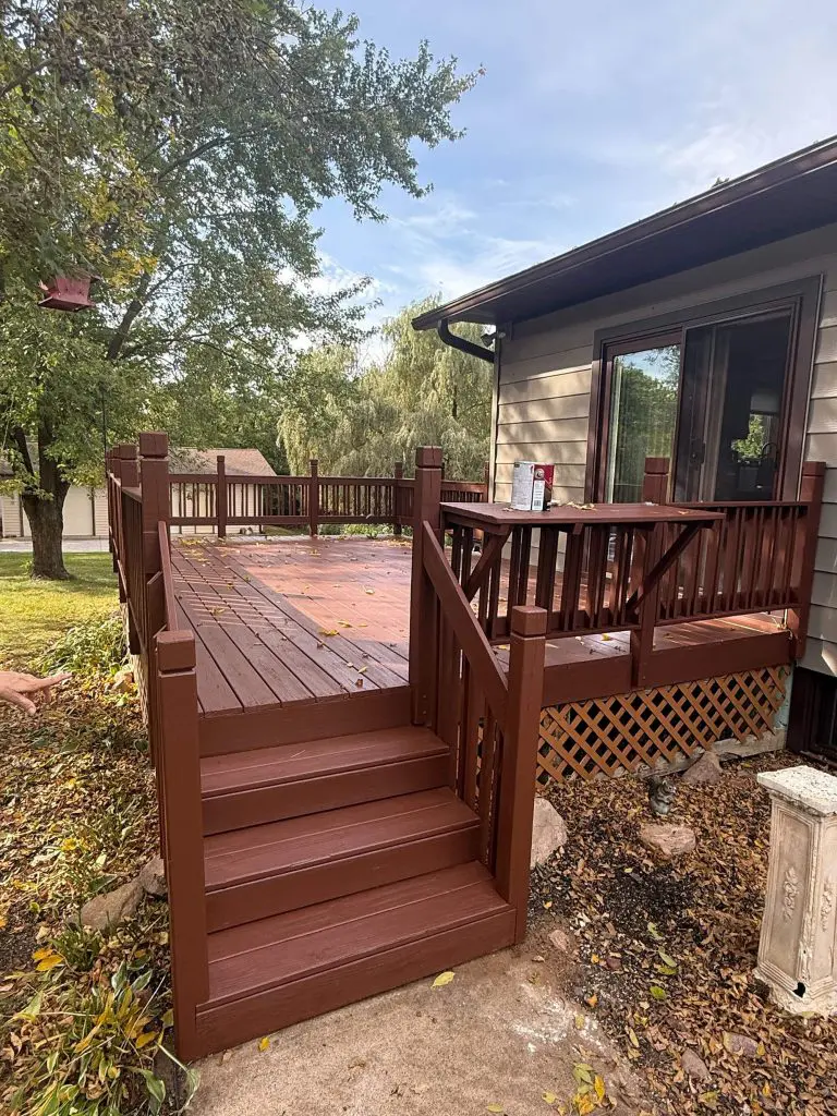 A picturesque bi-level home with white siding, brick lower half, and a striking red door, perfectly finished by Texas Star Painting of Austin.