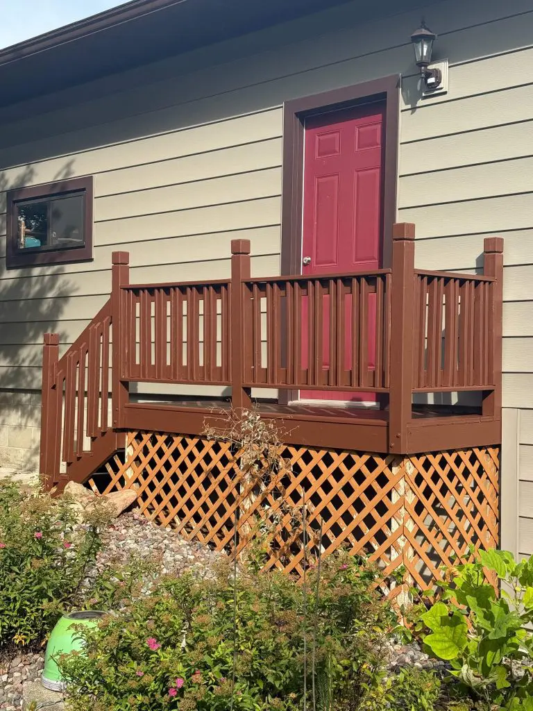 A detailed view of a freshly stained brown deck and a vibrant magenta door, executed with precision by Texas Star Painting of Austin.