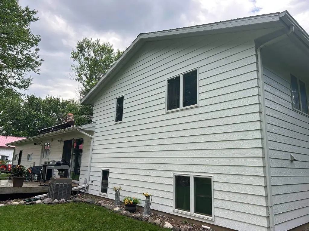 A perfectly refreshed, crisp white siding exterior under a cloudy sky, expertly finished by Texas Star Painting of Austin.