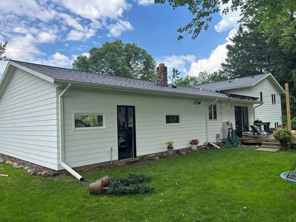 Freshly painted white siding renovation on a suburban home under a bright sky by Texas Star Painting of Austin.