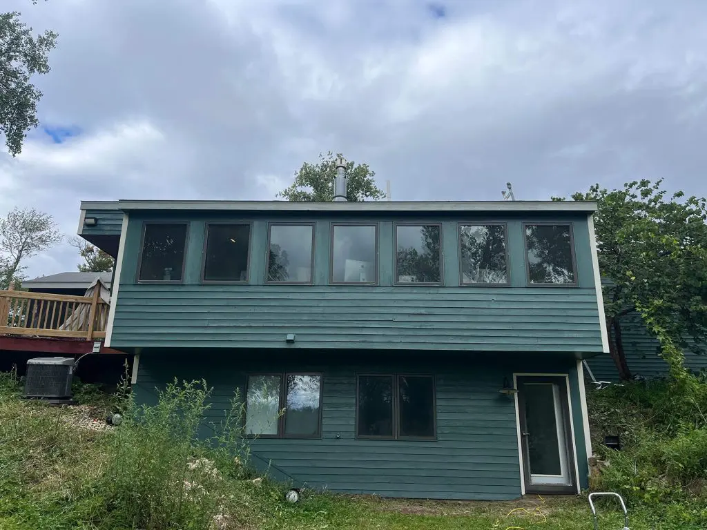 Dark teal exterior siding and trim on a modern home needing a fresh coat of color from Texas Star Painting of Austin.