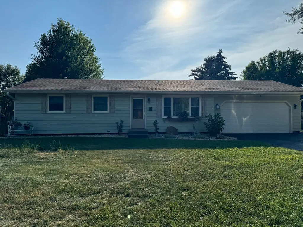 A crisp, single-story ranch home exterior basks in the sunlight, showcasing the flawless painting work by Texas Star Painting of Austin.