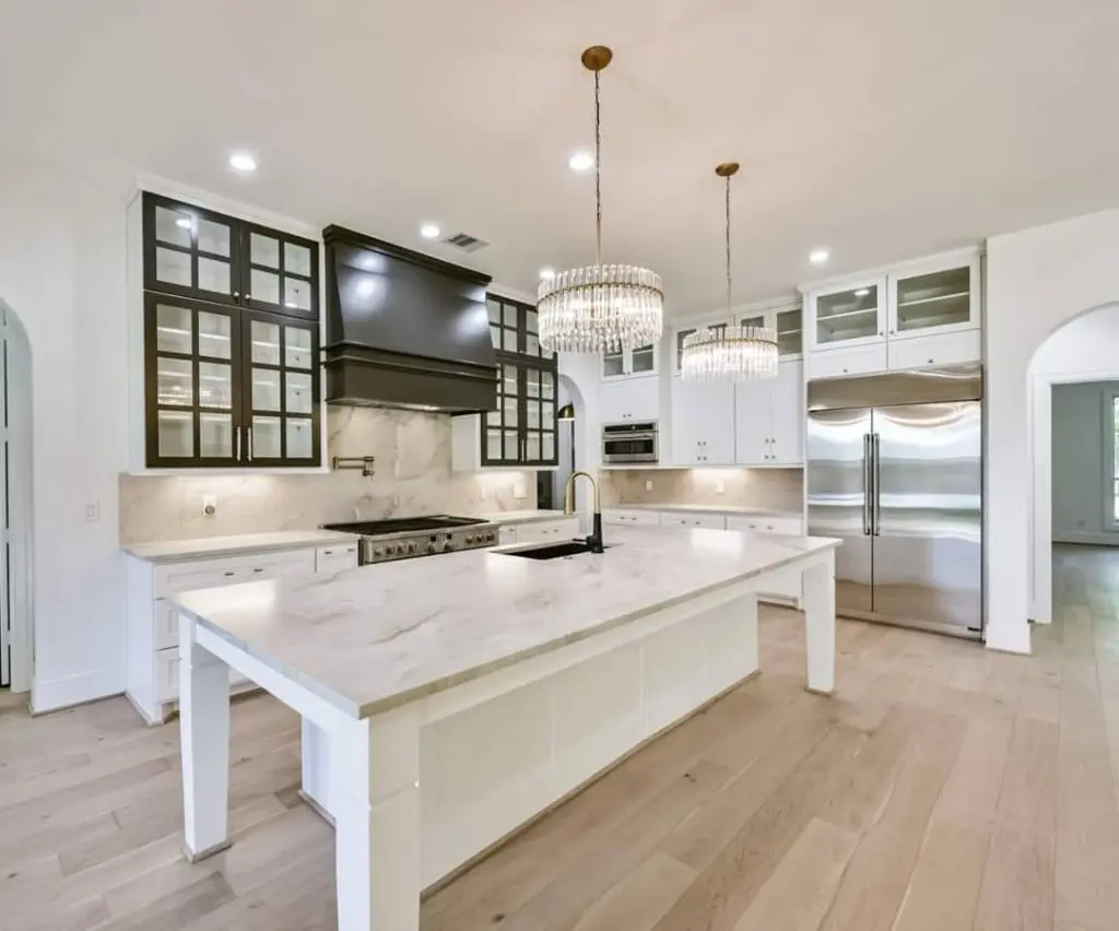 A stunning, modern luxury kitchen featuring a marble island and high-contrast cabinet finishes by Texas Star Painting of Austin.
