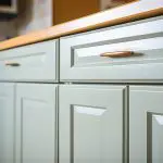 Freshly painted kitchen cabinets in a soft neutral finish, showing why is cabinet painting worth it for updating older kitchens