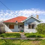 Signs your exterior paint is failing on an older home with peeling siding, flaking paint, and visible surface wear on the exterior walls
