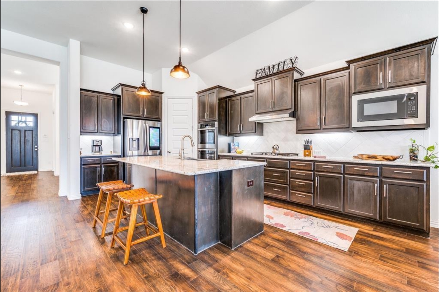 kitchen featuring dark cabinets and a large granite island, expertly finished by Texas Star Painting of Austin.