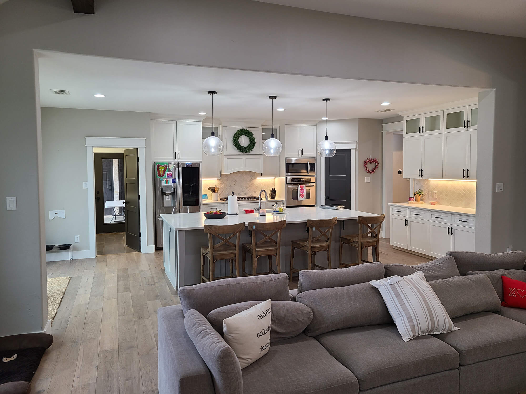 A newly painted, bright white kitchen and open-concept living area by Texas Star Painting of Austin.