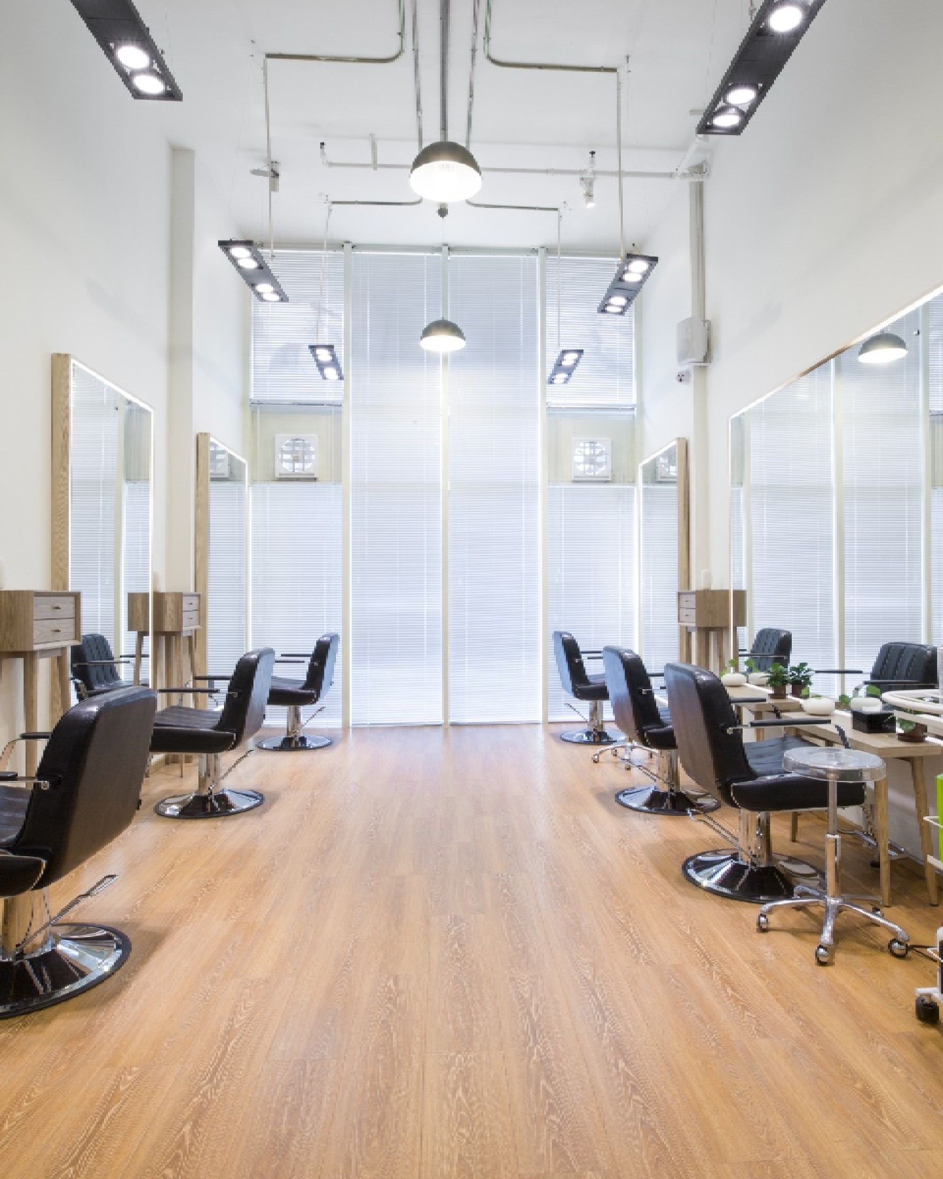 A modern, brightly interior with a light wood floor and symmetrical black styling chairs, featuring fresh paintwork by Texas Star Painting of Austin.