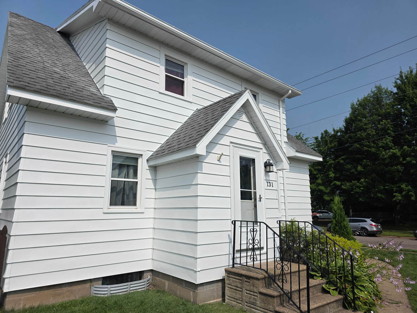 White two-story home with fresh exterior paint and front entry stairs, completed by painters in Austin, TX.